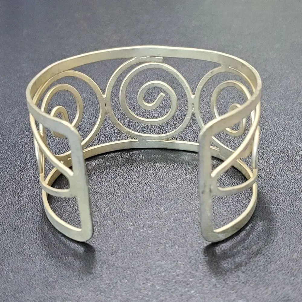 Gold tone swirly bangle cuff bracelet